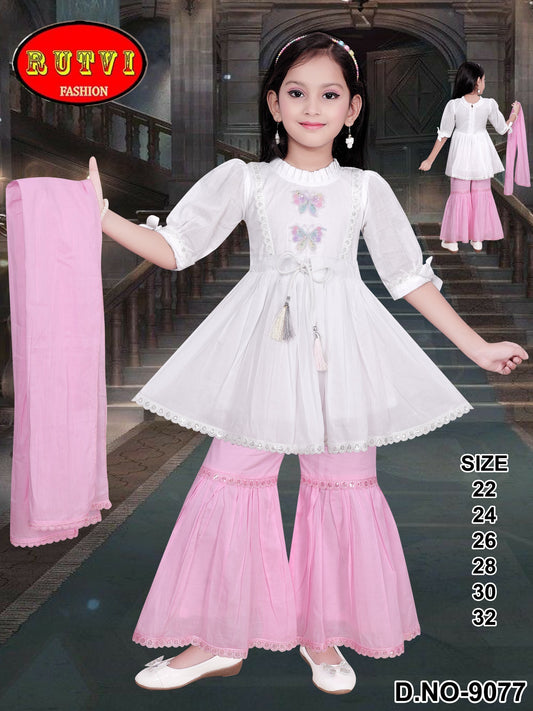Girl wearing white frock top with pink sharara pants set, holding matching dupatta, festive ethnic dress for kids.