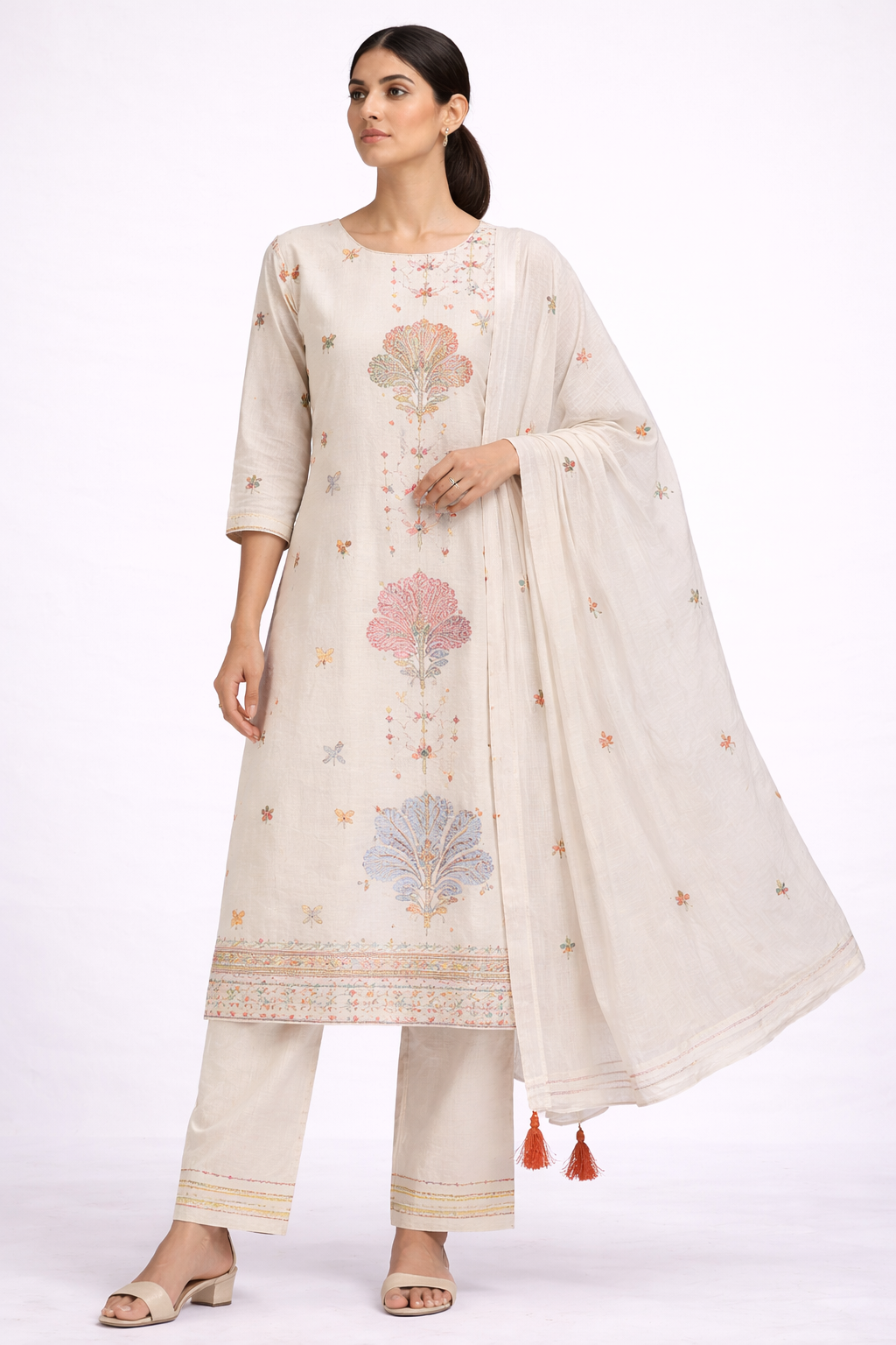 Woman wearing a cream embroidered traditional outfit with a white background