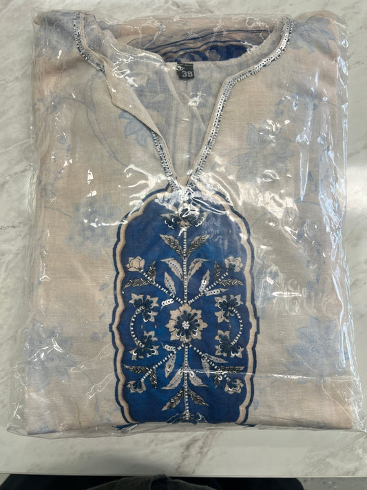 Folded beige and blue embroidered kurti with sequin accents, packaged in plastic.