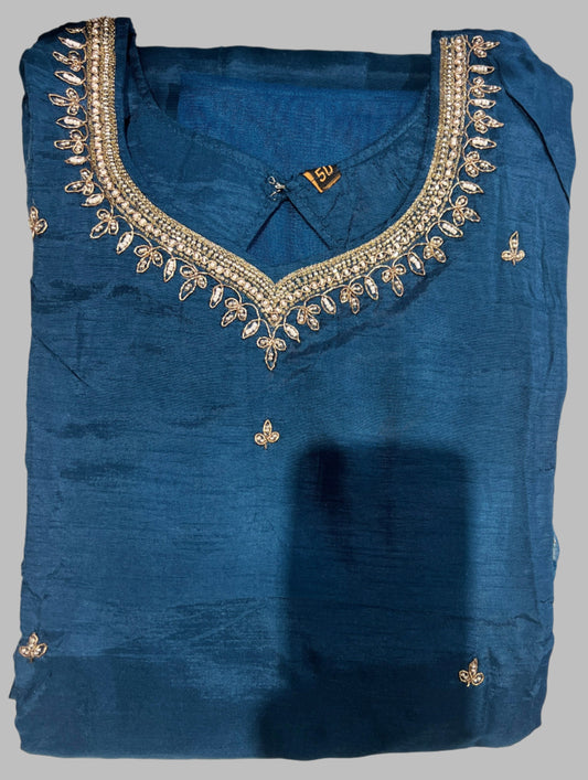 Blue festive kurta with gold embroidery and embellished neckline, folded neatly on a gray background