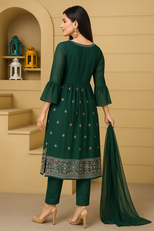 Woman wearing a green traditional outfit with a beige wall and shelves in the background