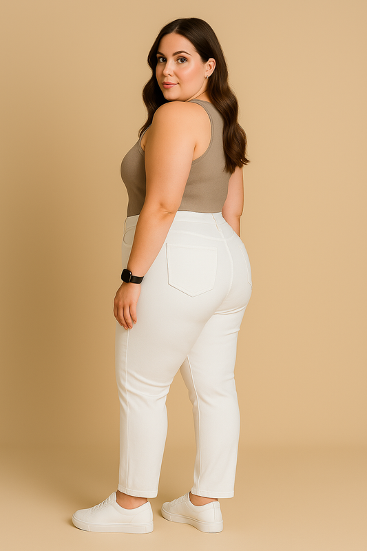 Woman wearing a brown tank top and white pants against a beige background