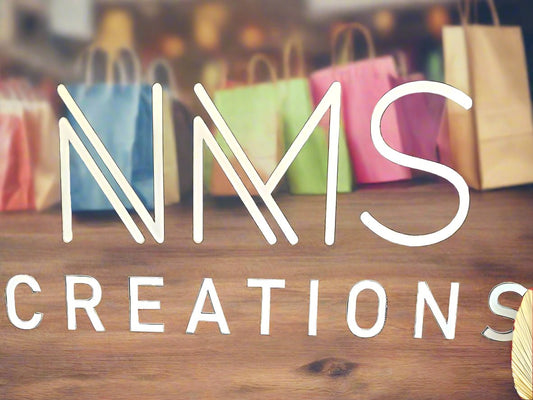 Storefront image with colorful shopping bags and 'CREATIONS' text on wooden surface
