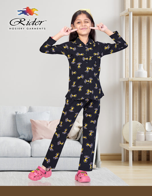 Smiling girl in black cartoon-print pajama set and pink slippers standing in modern living room