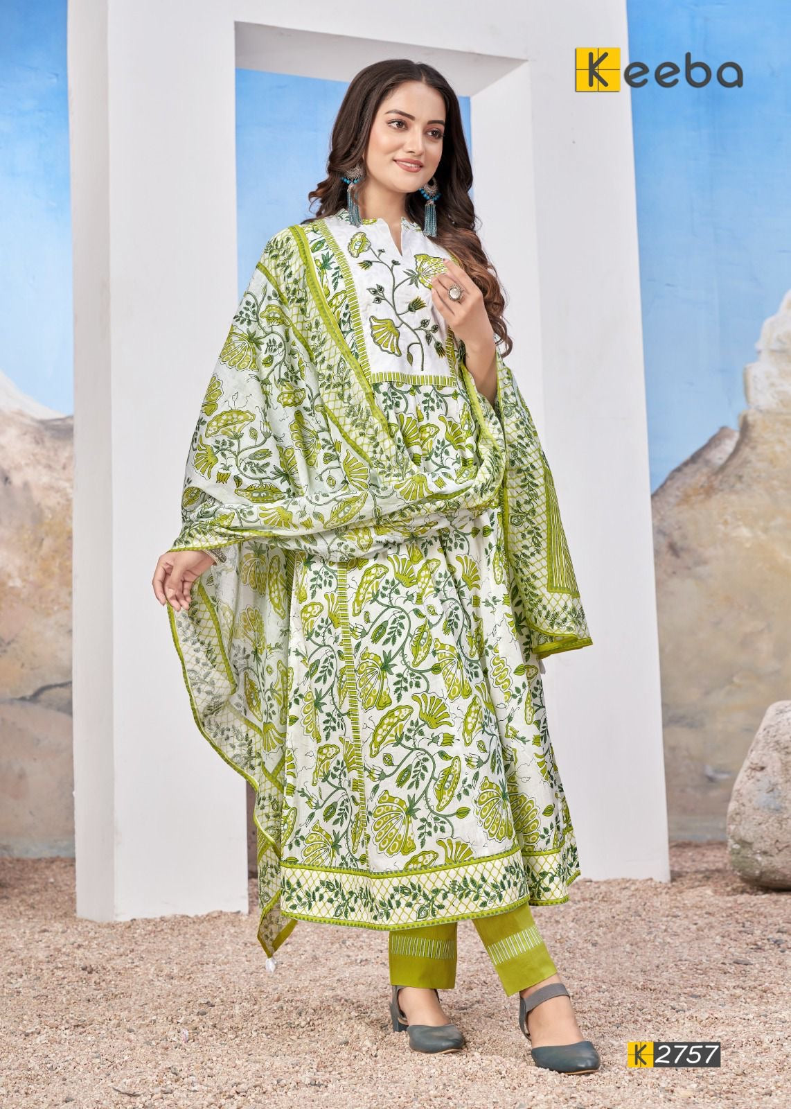 Woman in green and white floral printed salwar suit with dupatta, standing outdoors