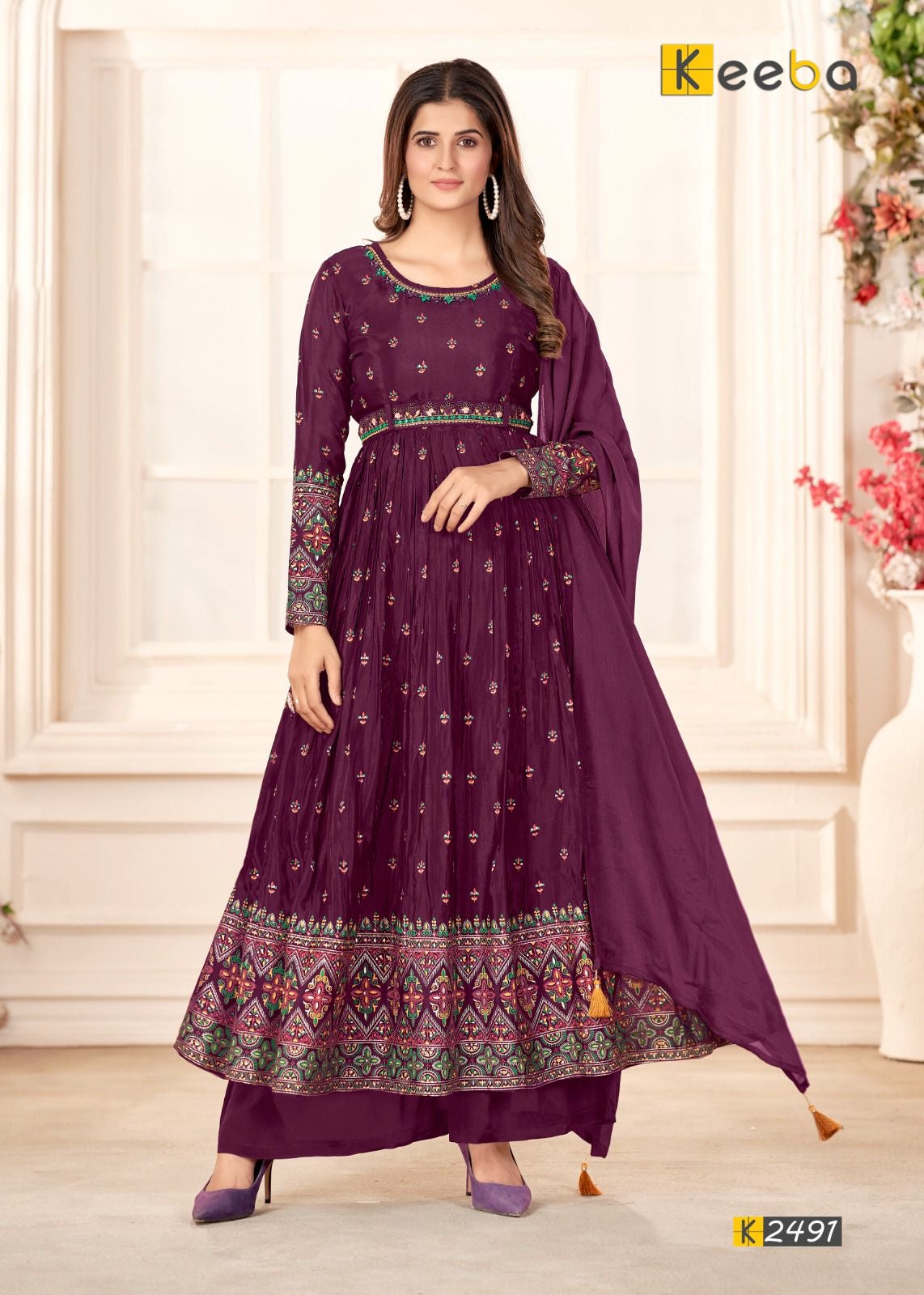 Woman wearing purple embroidered Anarkali suit with dupatta, traditional festive outfit