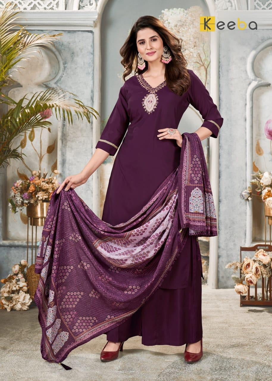 Woman in purple embroidered festive salwar suit with dupatta, standing in elegant setting