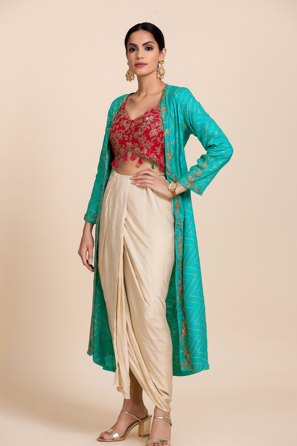 Woman wearing a traditional outfit with a red blouse, beige saree, and teal jacket on a beige background