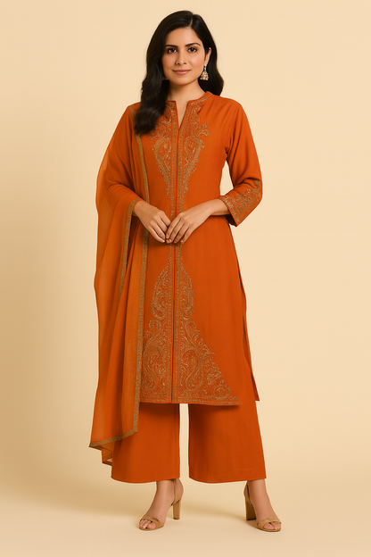 Woman wearing an orange embroidered outfit with a beige background