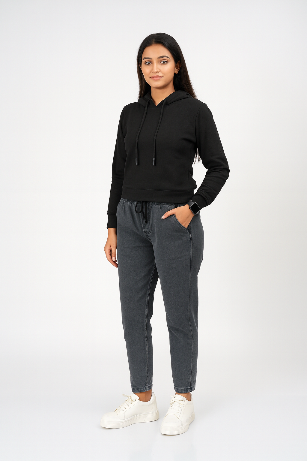 Woman wearing a black hoodie and gray sweatpants on a white background