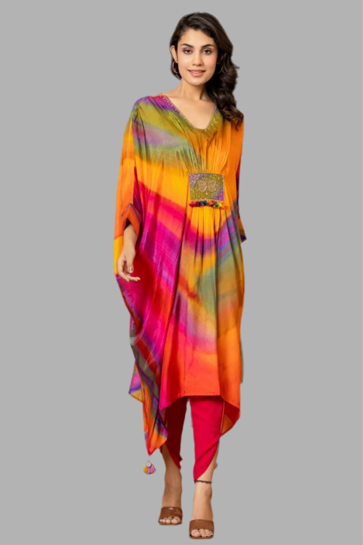 Woman in colorful tie-dye kurta with embroidered patch and pink leggings on grey background