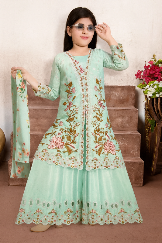 Woman wearing a light green embroidered traditional outfit with a floral design, standing against a neutral background.