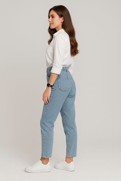 Woman wearing light blue jeans and a white shirt on a plain background