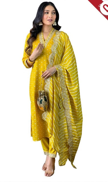 Woman wearing a yellow festive salwar suit with dupatta, gold embroidery, and statement earrings