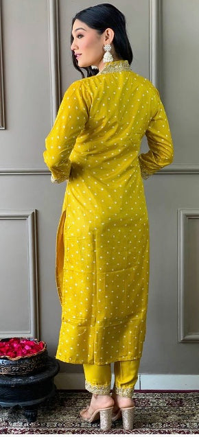 Woman modeling a yellow polka dot festive kurta and churidar set, standing indoors