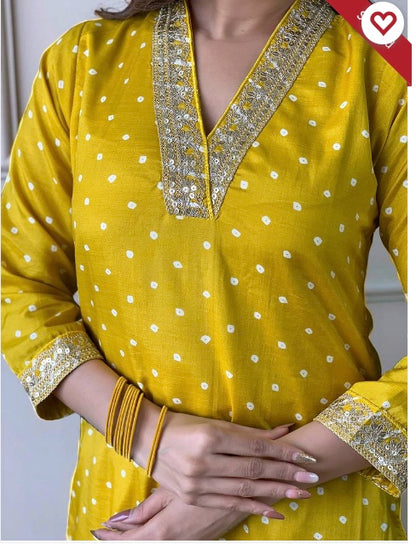 Woman wearing a yellow kurta with gold embroidery and polka dots, accessorized with bangles