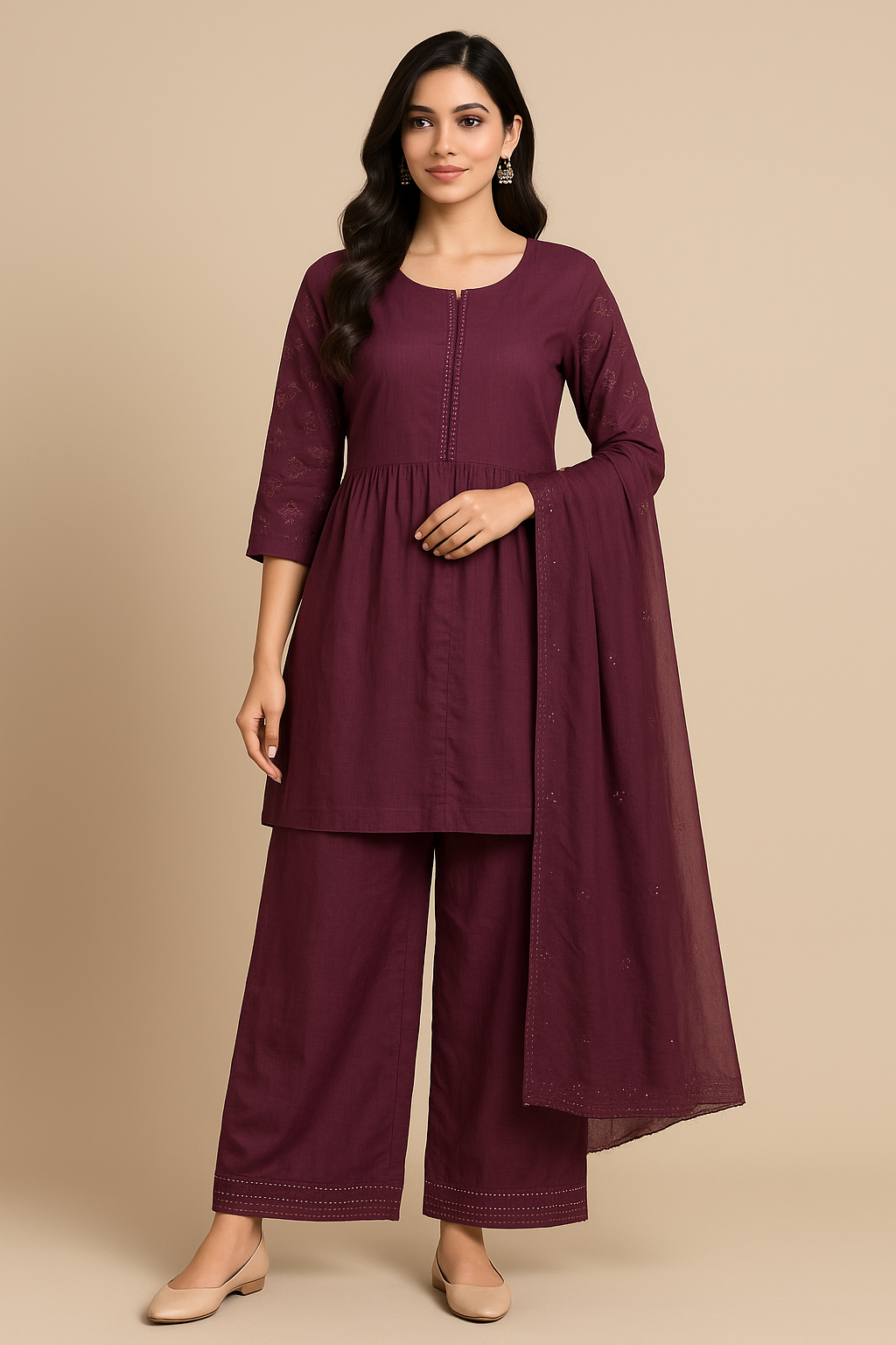 Woman wearing a maroon outfit with a beige background