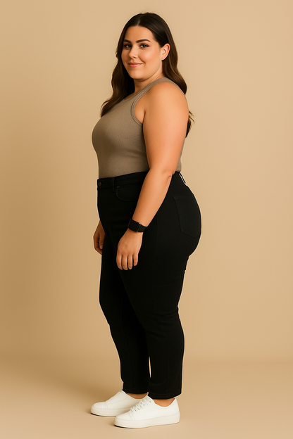 Woman wearing a beige tank top and black pants on a beige background