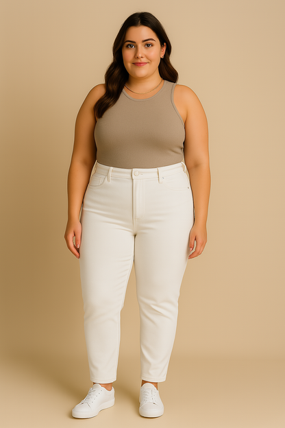Woman wearing a beige tank top and white pants against a beige background