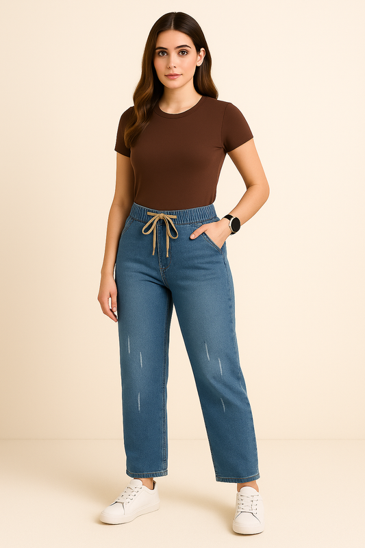 Woman wearing a brown top and blue jeans on a beige background