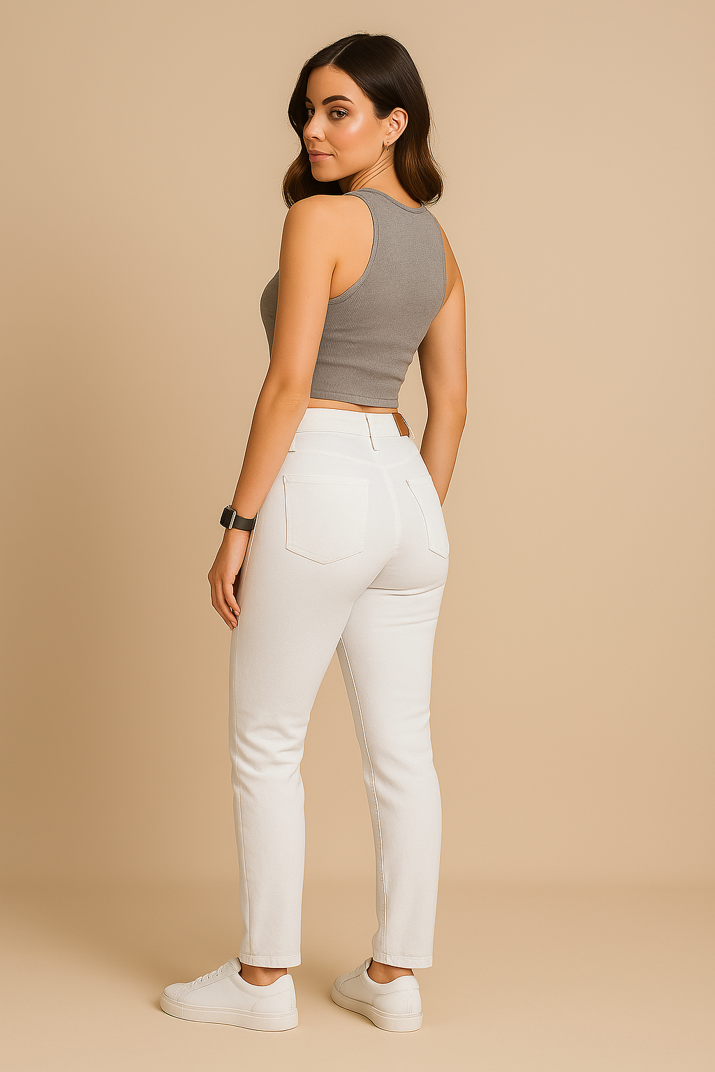 Woman wearing a brown crop top and white pants on a beige background
