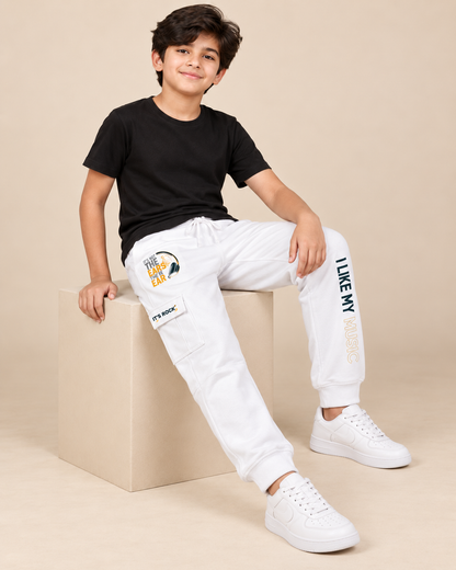 Boys white cotton cargo trousers with music graphic, seated lifestyle model view