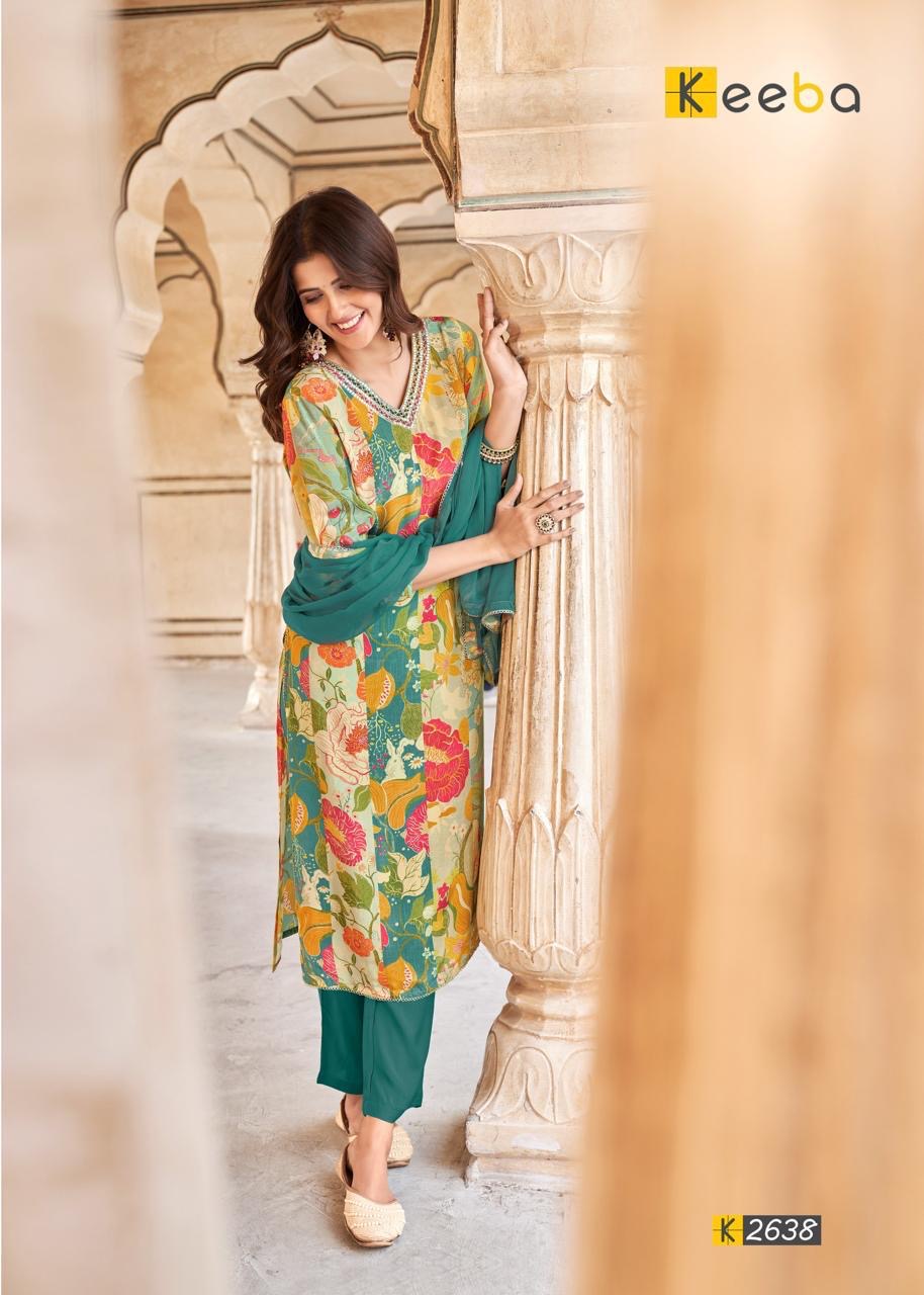Woman in floral print kurta with green dupatta and pants, traditional architecture background