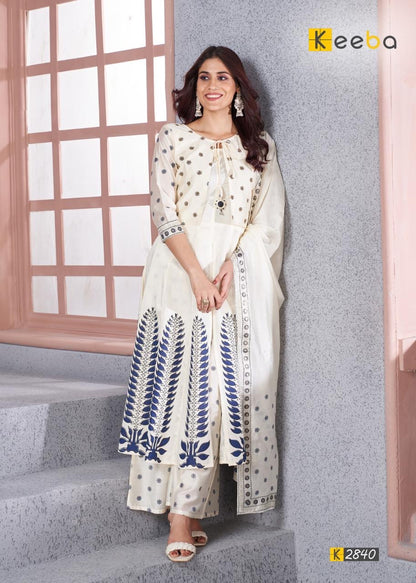 Woman in white and blue ethnic kurta palazzo set with dupatta, standing indoors
